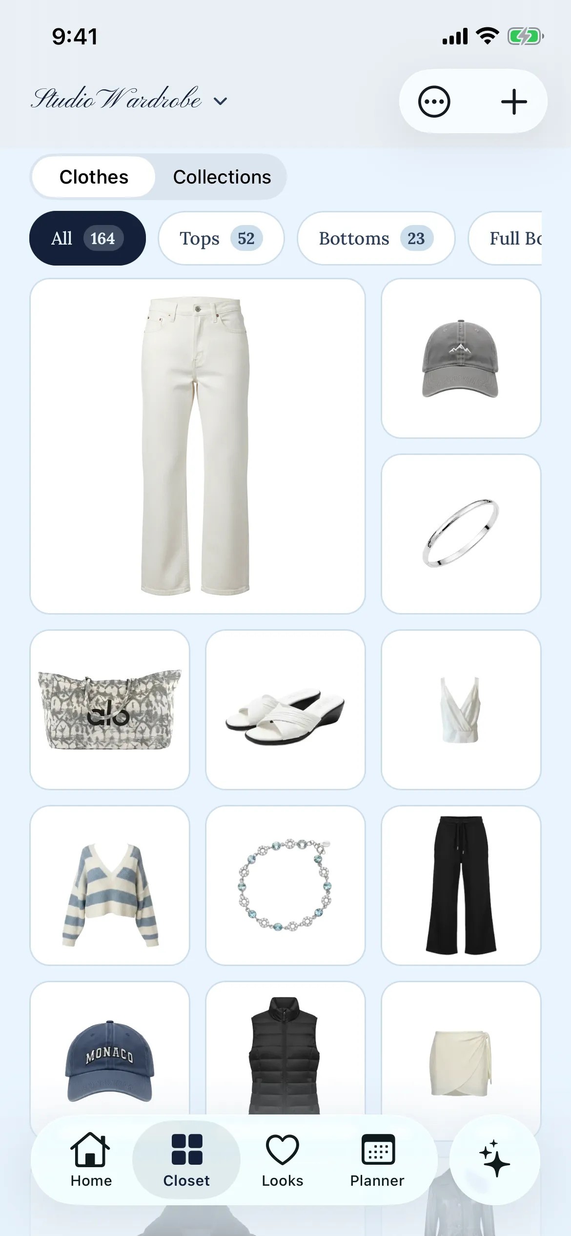 The Layers closet on iPhone: a grid of photographed garments — cream jeans, a grey cap, a striped knit, black trousers — under filters reading All 164, Tops 52 and Bottoms 23.